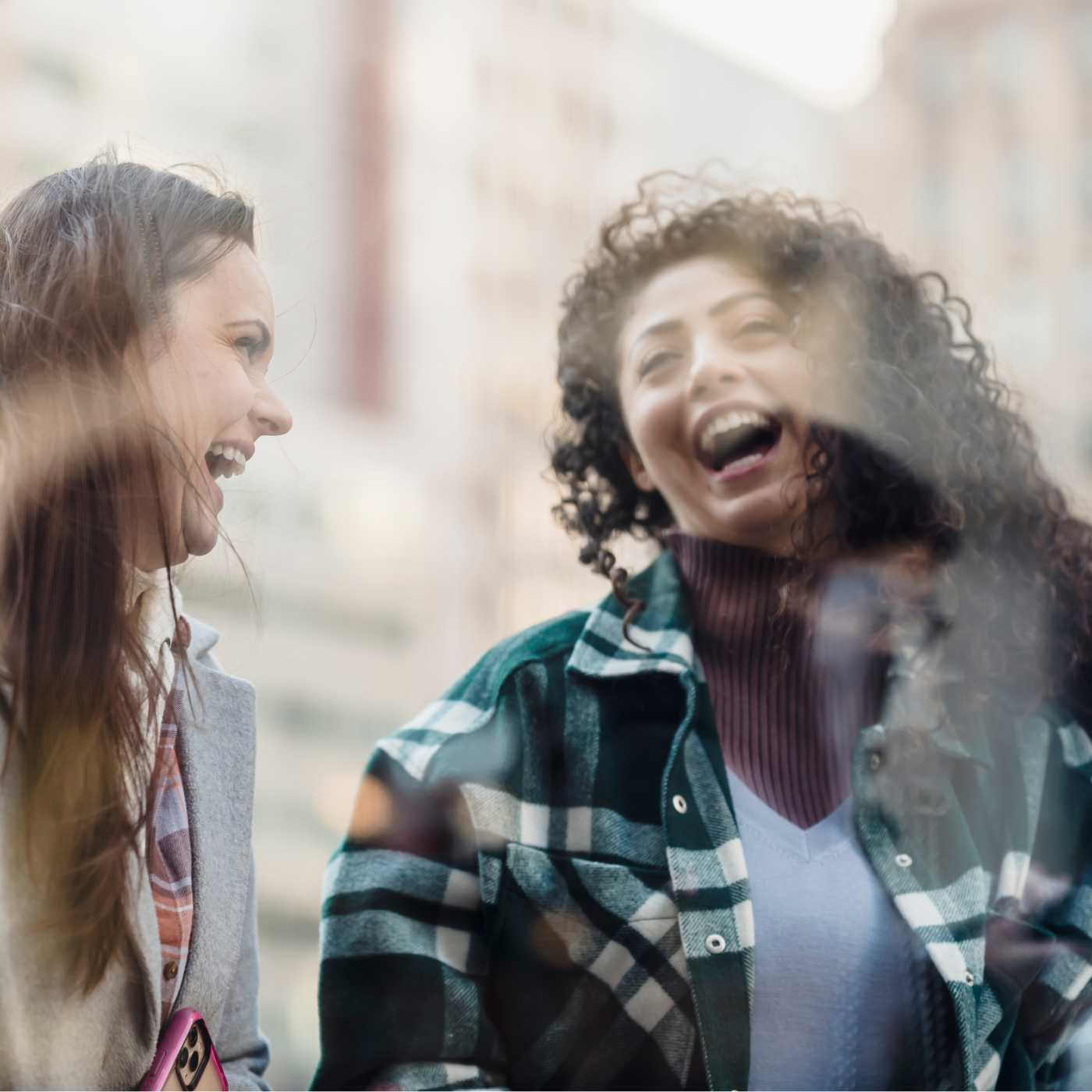 Två kvinnor skrattar i ett avslappnat samtal utomhus i Strömstad och visar hur vänskaper växer ur naturliga möten.