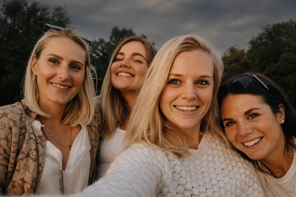 hitta ett tjejgäng – fyra kvinnor tar en selfie tillsammans utomhus