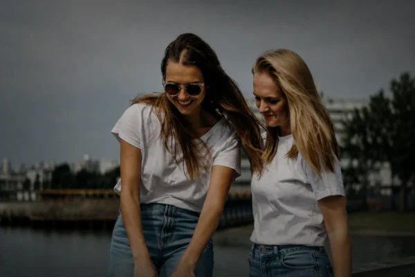 Två tjejer som visar hur man bli en bra vän genom att skratta och njuta av varandras sällskap utomhus