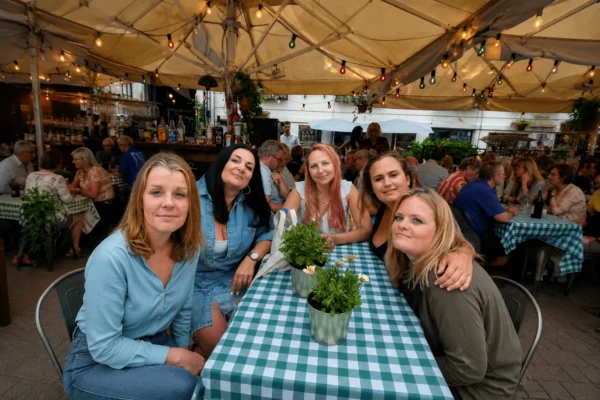 Fem kvinnor sitter tillsammans på en uteservering i Malmö efter att ha träffat nya vänner genom Gofrendly.