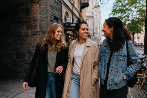 Tre kvinnor promenerar och skrattar i Stockholm – för dig som är ensam i Stockholm och vill hitta vänner