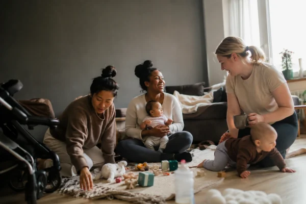 hitta mammalediga vänner – tre mammor sitter på golvet och umgås med sina bebisar hemma